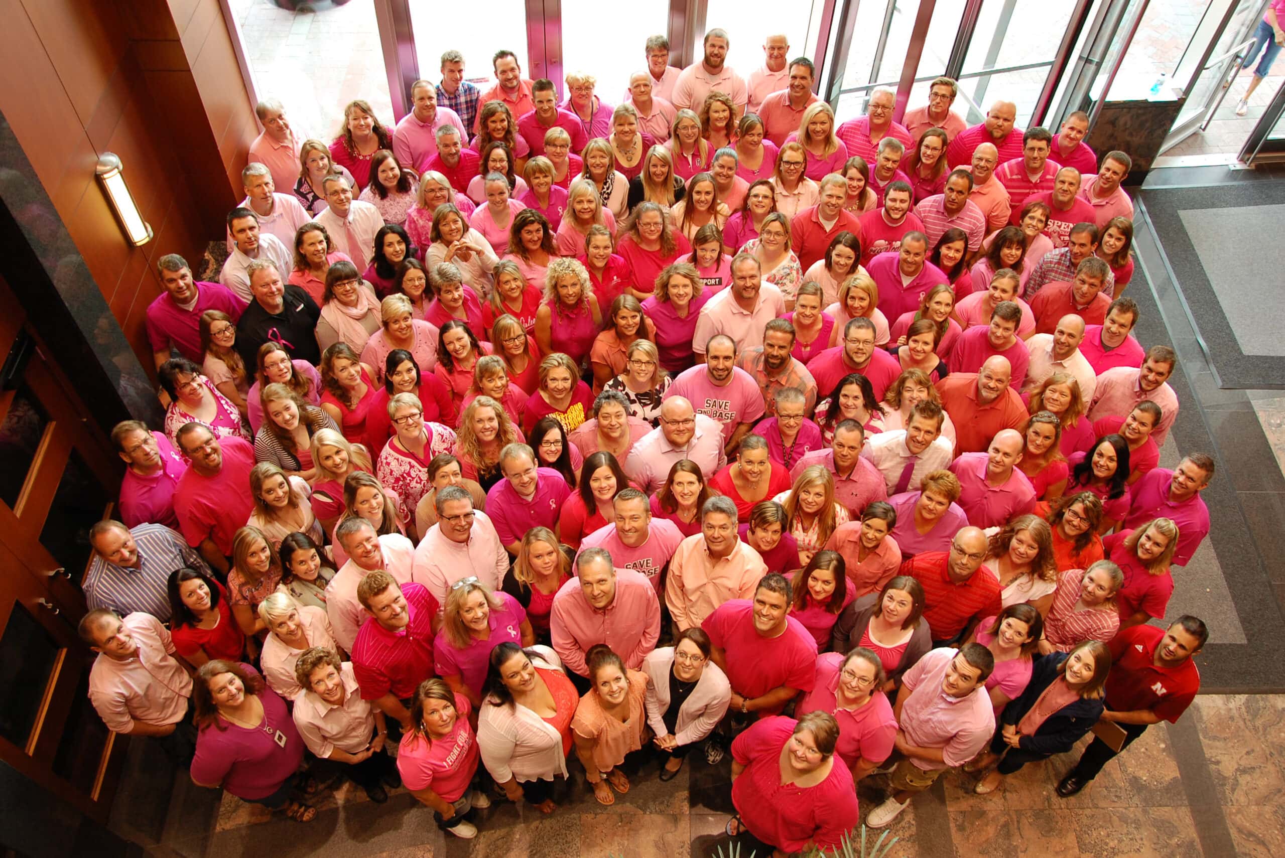 Photo from above of a large group of GreatAmerica employees wearing pink for breast cancer awareness.