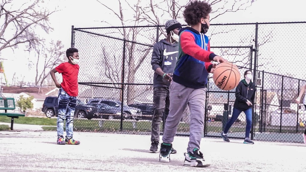 A group of kids playing basketball outside.