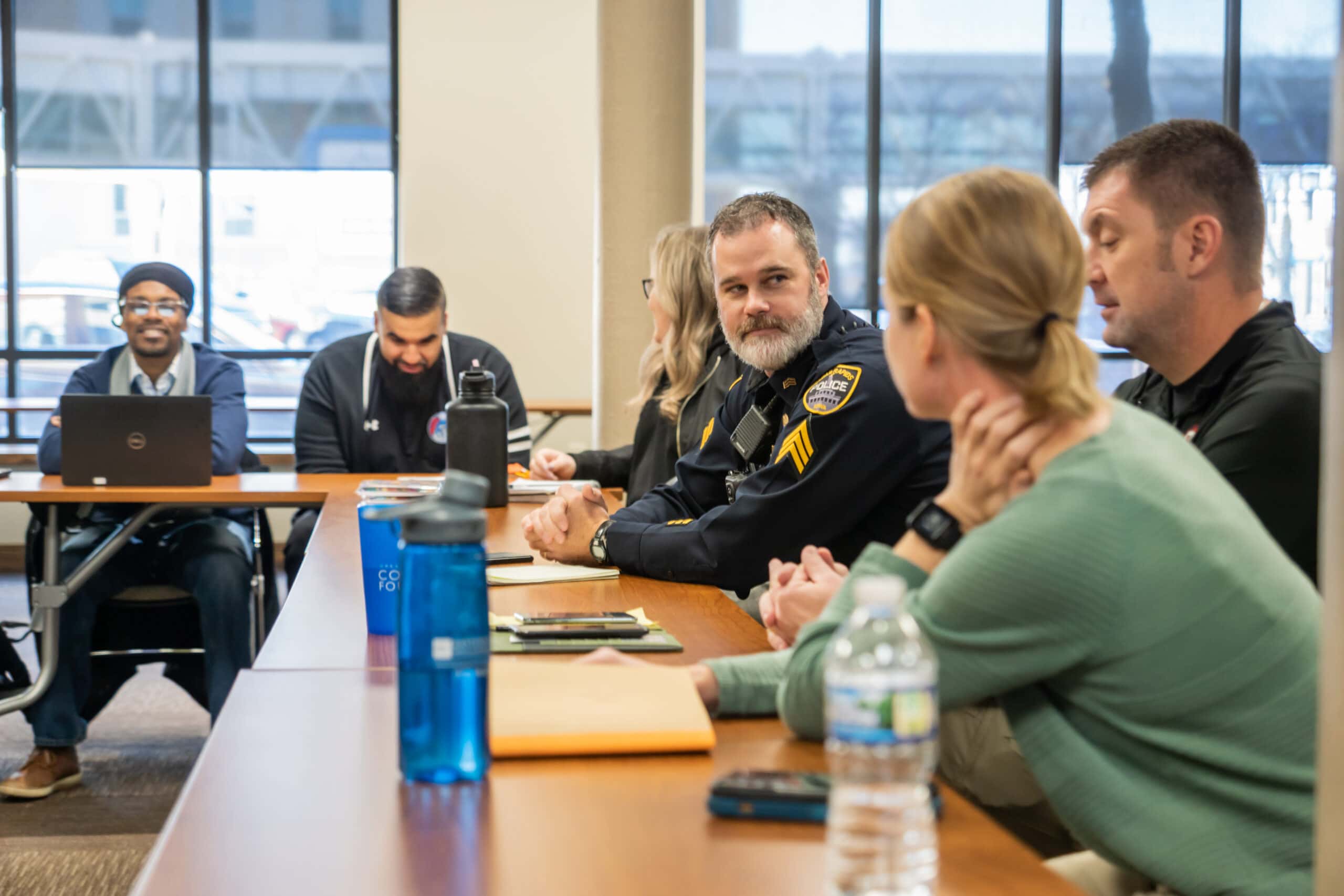 Photo of law enforcement officers and community members discussing Group Violence Intervention.