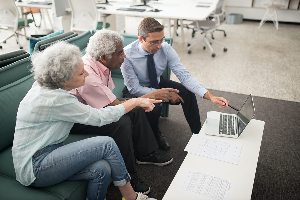 Photo of couple working with advisor on a couch.