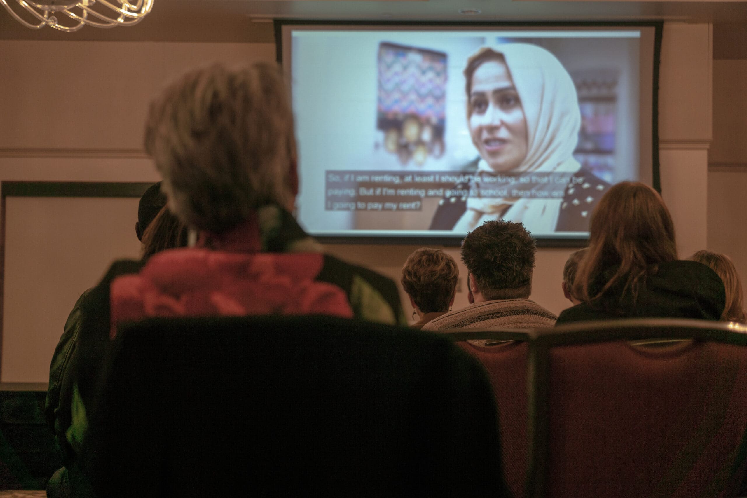 Photo of attendees watching a video at a Community Learning Series event.
